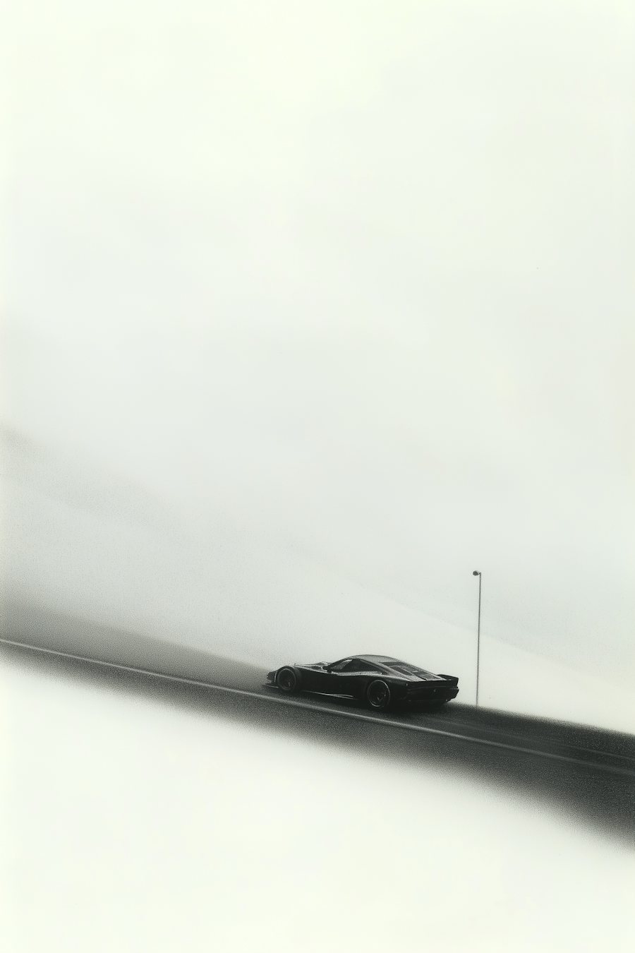 Une voiture sombre roule sur une route dans la brume.